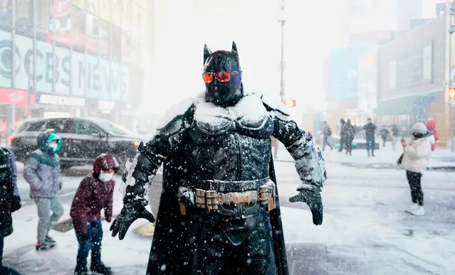 A person wearing a Batman costume stands under the snow in Times Square December 16, 2020 as Storm Gail hits the East coast. The Tri-State area is bracing for a major snowstorm. (Photo by Timothy A. Clary/AFP Photo)