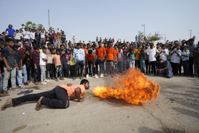 A man performs a fire stunt during a religious procession called Jal Yatra ahead of the annual Rath Yatra, or chariot procession of Hindu god Lord Jagannath in Ahmedabad, India, Saturday, June 22, 2024. The idols of Hindu God Jagannath, his brother Balabhadra and sister Subhadra, are carried in a procession in specially made chariots during the annual Rath Yatra which will be celebrated on July 7. (Photo by Ajit Solanki/AP Photo)