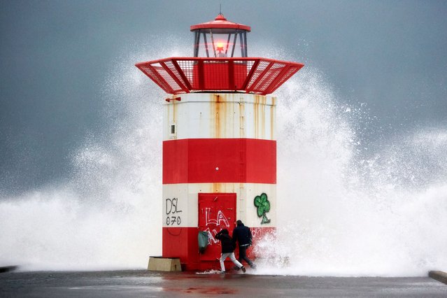 People stay cautious as waves crash against the pier amid Storm Benjamin on October 23, 2025 in The Hague, Netherlands. A code orange weather alert has been issued by the Netherlands meteorological institute KNMIfor western coastal provinces, with gusts up to 120 kilometers per hour forecast. (Photo by Pierre Crom/Getty Images)