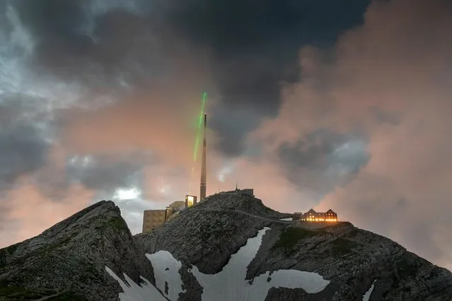 This handout image released by TRUMPF on January 16, 2023, shows a lightning rod in action at Santis Mountain in Switzerland. A powerful laser aimed at the sky can create a virtual lightning rod and divert the path of lightning strikes, a paper published in Nature Photonics demonstrates. The findings may pave the way for better lightning protection methods for critical infrastructure, such as power stations, airports and launchpads. (Photo by Martin Stollberg/TRUMPF via AFP Photo)
