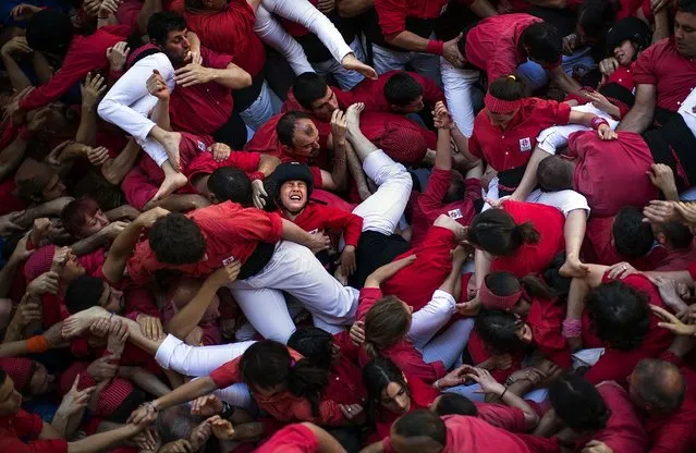 Members of the Castellers of Barcelona crowd together after the collapse of their  “castell”. A few participants were slightly wounded after the collapse of the human tower and were taken to a hospital. (Photo by Emilio Morenatti/Associated Press)