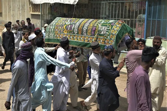 People carry coffins of a woman, who died in stampede, during her funeral, in Karachi, Pakistan, Saturday, April 1, 2023. Pakistani police arrested eight people in the southern port city of Karachi after a stampede killed several people at a Ramadan food and cash distribution point a day earlier. (Photo by Fareed Khan/AP Photo)