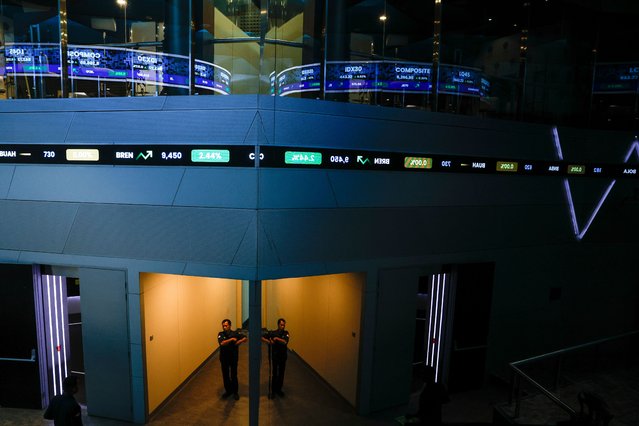A man walks as stock prices are reflected on the glass wall at the Indonesian Stock Exchange building in Jakarta, Indonesia, 05 November 2025. The Central Statistics Agency (BPS) recorded that the Indonesian economy grew 5.04 percent year-on-year in the third quarter of 2025. (Photo by Mast Irham/EPA)