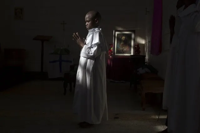 A boy prays in a church of the Legio Maria during Sunday mass in Korogocho, Nairobi, Kenya, July 5, 2015. (Photo by Siegfried Modola/Reuters)