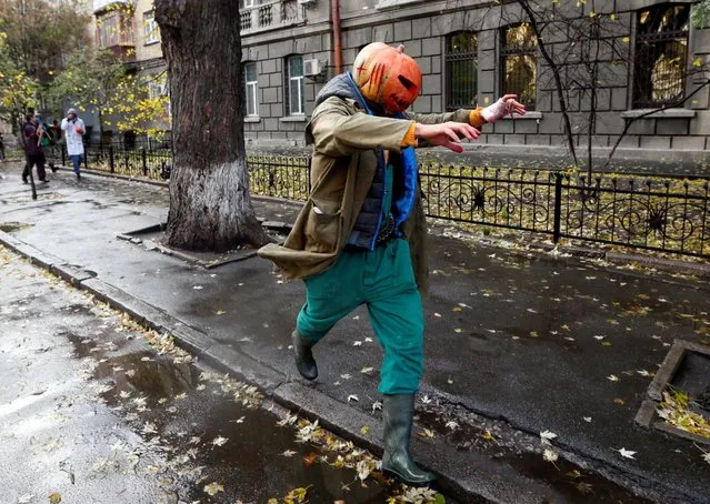 A participant wearing a pumpkin on his head runs along a street as he takes part in a Zombie Walk parade during Halloween celebrations in Kiev, Ukraine October 30, 2016. (Photo by Valentyn Ogirenko/Reuters)