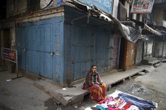 A vendor sits outside closed shops as she waits for customer along the road during the general strike independently called by the Unified Communist Party of Nepal (Maoist) and led by 30 party alliance and the Communist Party of Nepal (Maoist), demanding that the drafting of the new constitution is done on time through consensus, in Kathmandu January 13, 2015. (Photo by Navesh Chitrakar/Reuters)