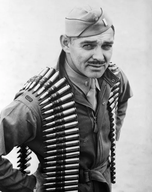 First Lieut. Clark Gable, former movie actor now an aerial gunner in the Army Air Forces, wears a double shoulder sling of .50 caliber machine gun bullets in taking off on a practice firing mission at Tyndall Field in Panama City, Florida on January 20, 1943. (Photo by AP Photo)