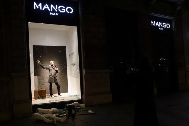 A man poses in a damaged window of a store next to broken mannequins on the ground, as supporters of arrested Catalan rapper Pablo Hasel protest in Barcelona, Spain, February 20, 2021. (Photo by Nacho Doce/Reuters)