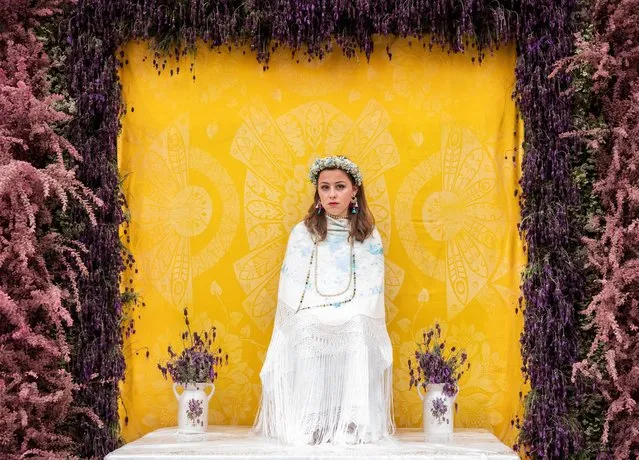A girl, La Maya, sits on the altar during the celebration of La Maya festivity on May 02, 2022 in Colmenar Viejo, Spain. Each year, Las Mayas, typically girls in Colmenar Viejo are chosen to sit at a freshly made flower altar to mark the new spring season. (Photo by Aldara Zarraoa/Getty Images)