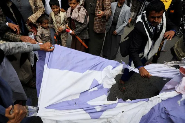 People tear an Israeli flag as they demonstrate to denounce the recent Israeli air strikes in the Gaza Strip, in Sanaa, Yemen on May 14, 2023. (Photo by Khaled Abdullah/Reuters)