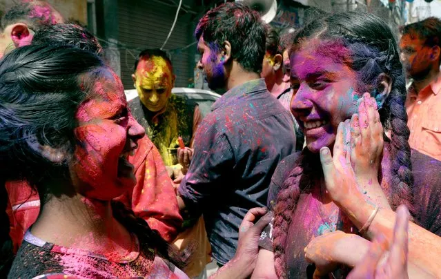 Indian people apply color on each other during Holi festival celebrations in Jammu, the winter capital of Kashmir, India, 28 March 2021. (Photo by Jaipal Singh/EPA/EFE)