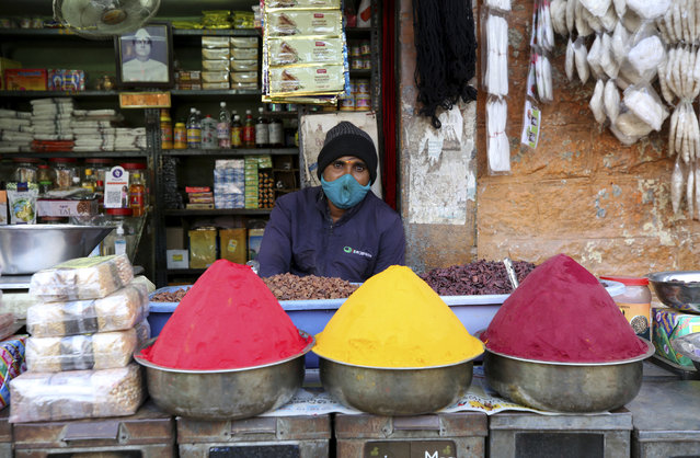 A shopkeeper wears a face mask as a precaution against the coronavirus waits for customers at a market in Bengaluru, India, Friday, November 20, 2020. India's total number of coronavirus cases since the pandemic began has crossed 9 million. Nevertheless the country's new daily cases have seen a steady decline for weeks now and the total number of cases represents 0.6% of India's 1.3 billion population. (Photo by Aijaz Rahi/AP Photo)