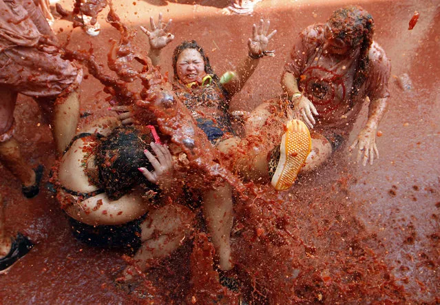 Revelers throw tomatoes at each other, during the annual “Tomatina”, tomato fight fiesta, in the village of Bunol, 50 kilometers outside Valencia, Spain, Wednesday, August 29, 2018. At the annual “Tomatina” battle, that has become a major tourist attraction, trucks dumped 160 tons of tomatoes for some 20,000 participants, many from abroad, to throw during the hour-long Wednesday morning festivities. (Photo by Alberto Saiz/AP Photo)
