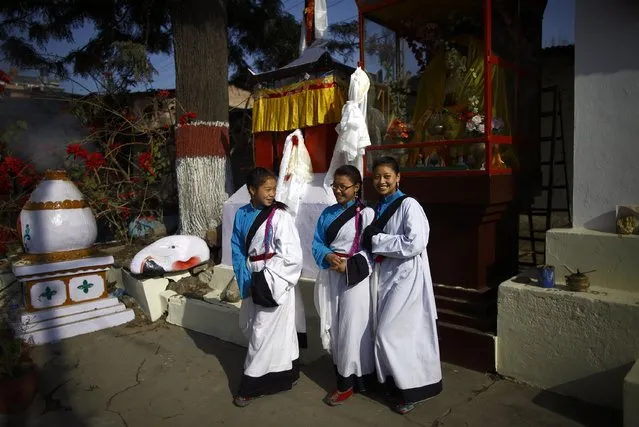 Tibetan girls dressed in traditional attire walk near the monastery after offering prayers in a function organised to mark Losar or the Tibetan New Year at Tibetan Refugee Camp in Lalitpur February 19, 2015. (Photo by Navesh Chitrakar/Reuters)