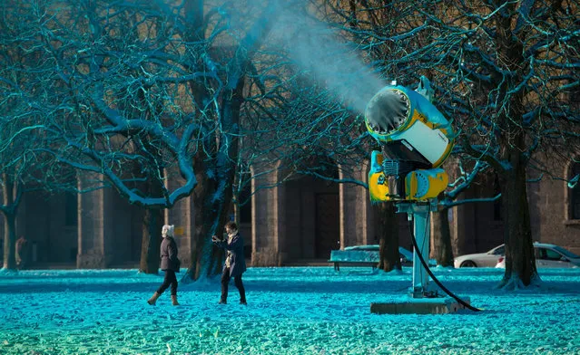A snow canon blows colourful artificial snow on a lawn in front of the Pinakothek museum in Munich, Germany, 18 January 2016. Artist Philipp Messner attempts to sharpen the perception of reality through his installation “Clouds”. (Photo by Sven Hoppe/EPA)