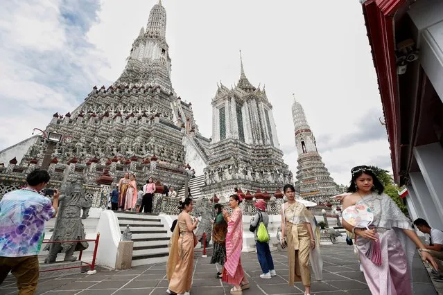 Foreign tourists dressed in Thai traditional costumes rented from a clothing rental shop visit Wat Arun or Temple of Dawn in Bangkok, Thailand on September 12, 2023. The first official cabinet meeting of Thailand's new government will discuss the proposed visa-free policy for Chinese visitors to encourage more arrivals as a main strategy to boost the country's tourism industry. The visa exemptions for Chinese visitors' policy is expected to start from 01 October 2023 onwards, according to Thai Prime Minister Srettha Thavisin. (Photo by Rungroj Yongrit/EPA/EFE)