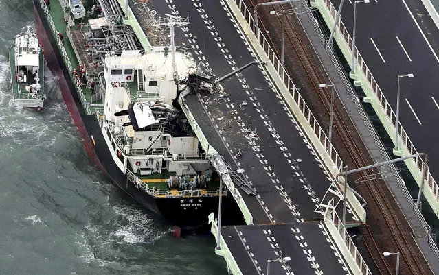 A tanker is seen after it slammed into the side of a bridge connecting the airport to the mainland, damaging part of the bridge and the vessel in Osaka, western Japan, Tuesday, Sepember. 4, 2018. (Photo by Kentaro Ikushima/Mainichi Newspaper via AP Photo)