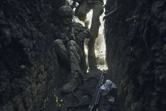 A soldier of Ukraine's 3rd Separate Assault Brigade jumps in a trench under the shelling near Bakhmut, the site of fierce battles with the Russian forces in the Donetsk region, Ukraine, Monday, September 4, 2023. (Photo by Libkos/AP Photo)