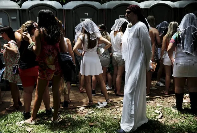Revellers wait outside portable toilets as they take part in the annual carnival block party known as “Casas comigo” or “Marry me” at the Pinheiros neighborhood in Sao Paulo, Brazil, January 30, 2016. (Photo by Nacho Doce/Reuters)