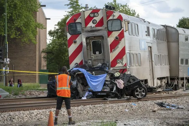Metra Police and Metra engineers work the scene where a train collided with a vehicle, killing 3 occupants including a child, in the 10300 block of South Vincennes in the East Beverly neighborhood, Sunday, June 27, 2021. (Photo by Tyler LaRiviere/Sun-Times via AP Photo)