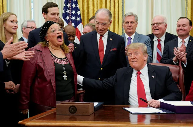 U.S. President Donald Trump reaches out to Alveda King, an evangelist and niece of the Rev. Martin Luther King Jr., as she speaks during a signing ceremony for the “First Step Act” and the “Juvenile Justice Reform Act” at the White House in Washington, U.S., December 21, 2018. (Photo by Joshua Roberts/Reuters)
