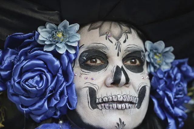 A woman dressed as a “Catrina” parades down Mexico City's iconic Reforma avenue during celebrations ahead of the Day of the Dead in Mexico, Sunday, October 22, 2023. (Photo by Ginnette Riquelme/AP Photo)