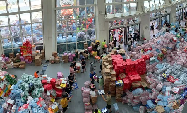 Supplies are stockpiled at the Pingyuan stadium in the flood affected city of Xinxiang in central China's Henan province on Sunday, July 25, 2021. Trucks carrying water and food on Sunday streamed into the Chinese city at the center of flooding that killed over 50 people, while soldiers laid sandbags to fill gaps in river dikes that left neighborhoods under water. (Photo by Dake Kang/AP Photo)