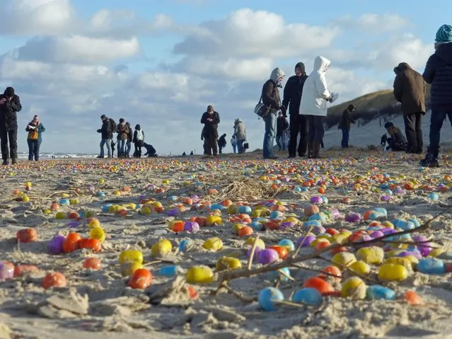 Tourists gather colorful egg capsules with toys lying washed up on the beach in Langeoog, Germany on January 05, 2017. The plastic eggs are now lining several kilometers of the island's sand beach. (Photo by Klaus Kremer/Picture-alliance/DPA/AP Images)