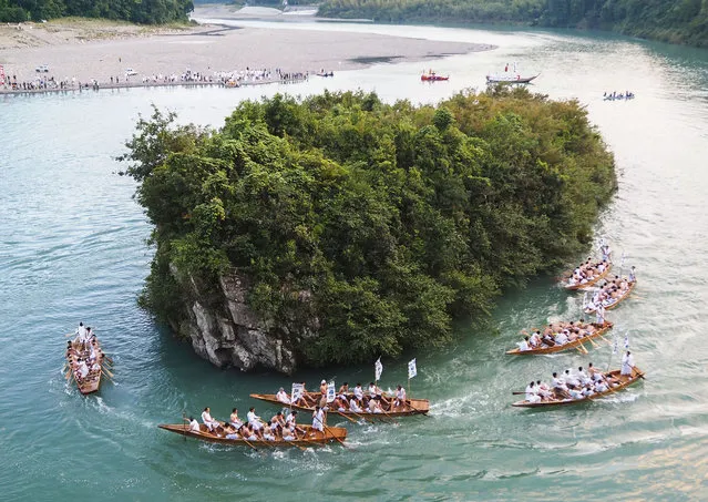 Wooden “speedboats” rowed by shirtless men compete in a traditional boating race as part of the Mifune festival on the Kumano River running near World Heritage-listed Kumano Hayatama Taisha Grand Shrine in Shingu in the western Japan prefecture of Wakayama on October 16, 2023. (Photo by Kyodo News/Newscom via Avalon)