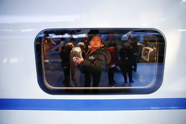 A boy checks his seat on a passenger train he boarded at the Beijing Railway Station in central Beijing, China January 13, 2017 as the annual Spring Festival travel rush begins ahead of the Chinese Lunar New Year. (Photo by Damir Sagolj/Reuters)