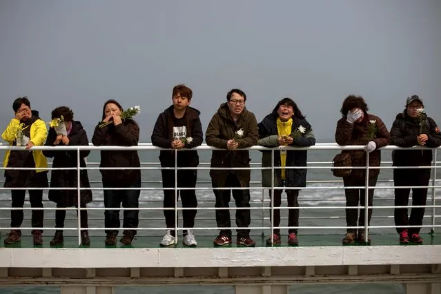 Relatives of victims of the Sewol ferry disaster weep as they stand on the deck of a boat during a visit to the site of the sunken ferry, off the coast of South Korea's southern island of Jindo April 15, 2015. (Photo by Ed Jones/Reuters)