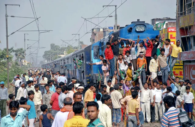 Supporters of India's Rashtriya Janata Dal party block the path of a passenger train during a protest against rising inflation on the outskirts of the eastern Indian city of Patna, April 27, 2010. (Photo by Krishna Murari Kishan/Reuters)