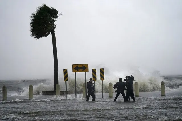 A news crew reports on the edge of Lake Pontchartrain ahead of approaching Hurricane Ida in New Orleans, Sunday, August 29, 2021. (Photo by Gerald Herbert/AP Photo)