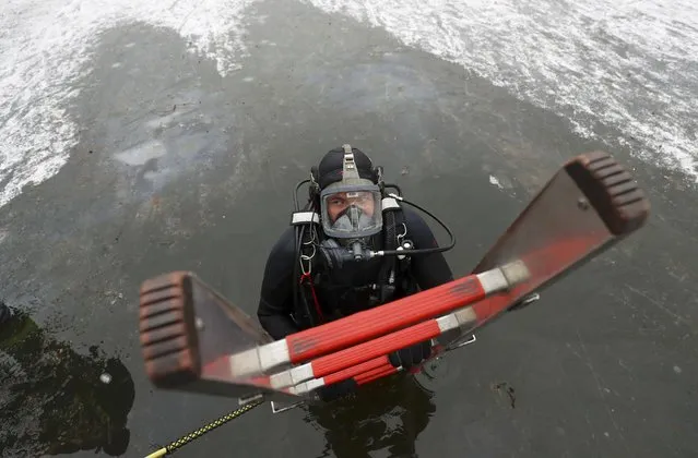 Martin Weitzendoerfer, diver of Frankfurt's firefighter rescue brigade, leaves a frozen lake during a rescue exercise in Frankfurt, Germany, January 24, 2017. (Photo by Kai Pfaffenbach/Reuters)