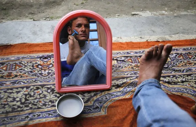 Amir Hussain Lone uses his feet to shave at his home in the village of Waghama Anantnag, south of Srinagar, the summer capital of Indian Kashmir, 04 March 2016. Lone, a 26-year-old man from the Kashmiri Anantnag district, despite being handicapped plays his favourite sports cricket, writes and does all other activities by using his feet and toes. Amir has not given up since he lost his both arms at the age of eight in a tragic accident at his fathers sawmill. (Photo by Frooq Khan/EPA)