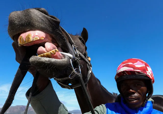 A horse handler poses with a horse during a beach parade at Muizenberg beach, in Cape Town, South Africa on January 5, 2024. (Photo by Esa Alexander/Reuters)