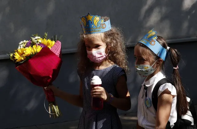 Two Romanian pre-school girlswearing blue printed toy crowns, rush for their classes at the “Leonardo da Vinci” Secondary School in Bucharest, Romania, 13 September 2021. In Romania, the school year 2021-2022 started on 13 September with physical attendance at classes for approximately 2.9 million students and preschoolers, and with the online presence of 2,400 students from localities affected by the new wave of covid-19. In the context of the increase in the daily number of SARS-CoV-2 infections, measures were taken to protect students' health, parents access to schools was restricted for the first day of school. In the first two months after the start of school, a vaccination campaign will be carried out for children over 12 years old, with Pfizer and Moderna vaccines. Wearing a protective mask by students and teachers is mandatory, both in the school and in its vicinity. (Photo by Robert Ghement/EPA/EFE)