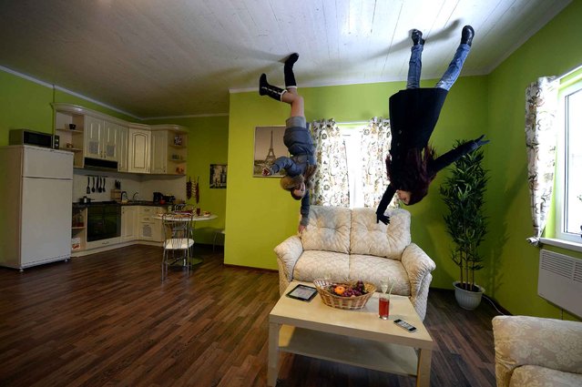 A picture rotated 180 degrees shows visitors walking inside an “Upside-down House” attraction at the VVTs the All-Russia Exhibition Center in Moscow, on January 14, 2014. The attraction to experience a new perspective of a house standing upside down was opened first time in Russia, the show organisers said. (Photo by Alexander Nemenov/AFP Photo)