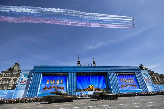 Russian military planes fly over, as  Russian T-14 Armata tank is ready to be towed at the Red Square during a preparation for general rehearsal for the Victory Day military parade which will take place at Moscow's Red Square on May 9 to celebrate 70 years after the victory in WWII, in Moscow, Russia, Thursday, May 7, 2015. (Photo by Alexander Zemlianichenko/AP Photo)