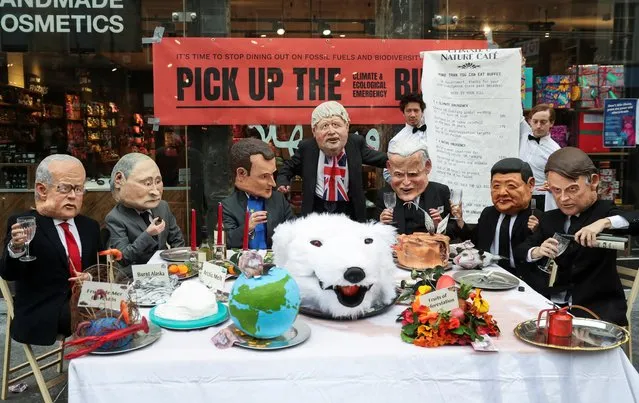 Activists wear masks depicting world leaders as they sit by a buffet marking the Climate and Ecological Emergency Bill during the UN Climate Change Conference (COP26), in Glasgow, Scotland, Britain, November 5, 2021. (Photo by Russell Cheyne/Reuters)