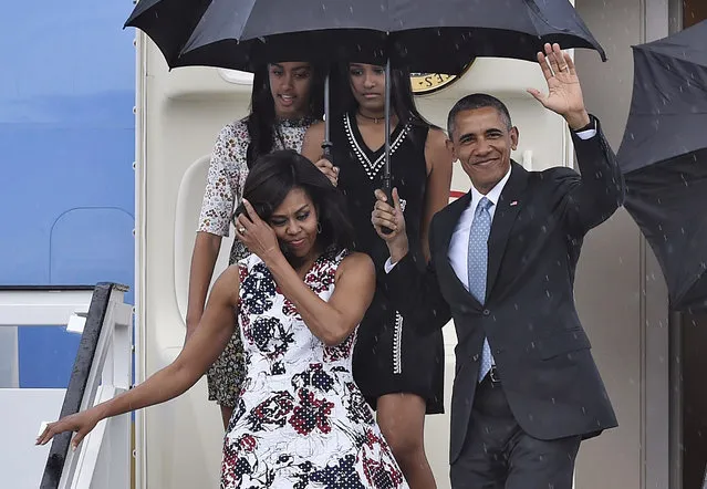 US President Barack Obama waves next to First Lady Michelle Obama (L) and their daughters Malia (L, behind) and Sasha upon their arrival at Jose Marti international airport in Havana on March 20, 2016. Barack Obama on Sunday became the first US president in 88 years to visit Cuba, touching down in Havana for a landmark trip aimed at ending decades of Cold War animosity. (Photo by Yuri Cortez/AFP Photo)