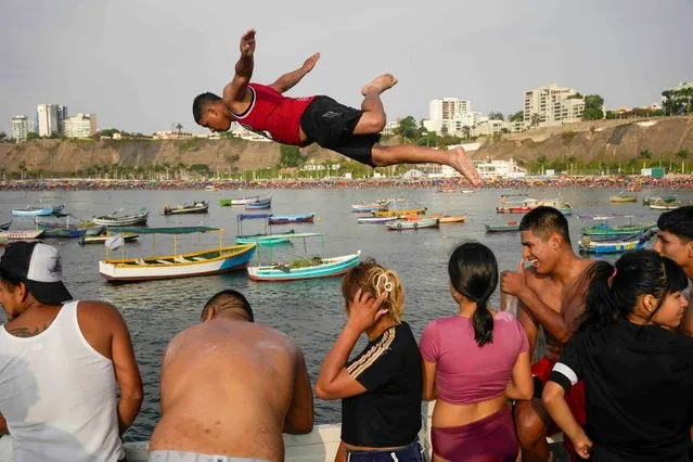 Alberto Chumpitaz dives from a dock at Pescadores Beach during the summer in Lima, Peru, Sunday, February 18, 2024. (Photo by Martin Mejia/AP Photo)