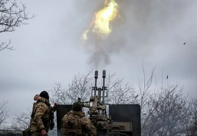 Ukrainian servicemen from an air defence unit of the 93rd Mechanized Brigade fire an anti aircraft cannon at a frontline, near the town of Bakhmut, Ukraine, on March 6, 2024. (Photo by Serhii Nuzhnenko/Radio Free Europe/Radio Liberty)