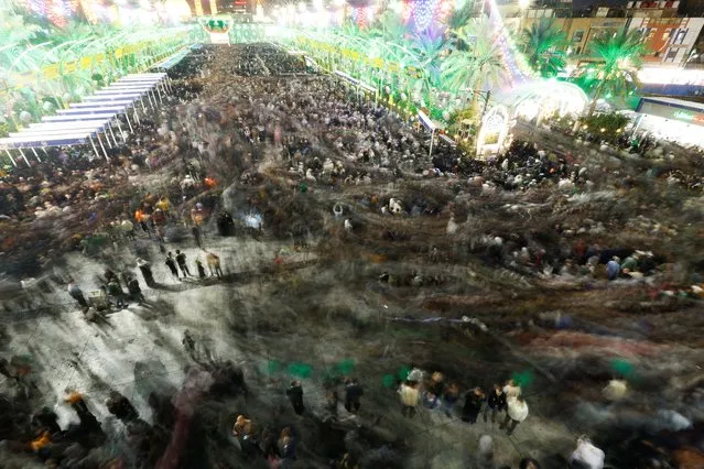 Shi'ite pilgrims gather to celebrate the Sha'abaniya, the birth of the 12th Imam al-Mahdi, a Messiah-like figure revered by Shi'ite Muslims, who believe he disappeared centuries ago, but never died, in the holy city of Karbala, Iraq on February 25, 2024. Picture taken with slow shutter speed. (Photo by Alaa al-Marjani/Reuters)
