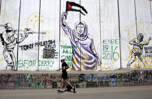 A participant runs in front of murals on the controversial Israeli separation wall as running enthusiasts take part in the “Right To Movement” Palestine Marathon 2016 run in the West Bank town of Bethlehem, 01 April 2016. Over 4,300 runners took part in marathon and shorter distance runs for the forth year in a row. The “Right To Movement” describes themselves as a non-profit, non-religious and non-political global running community. (Photo by Abed Al Hashlamoun/EPA)