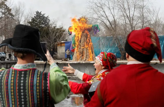Revellers cheer while they watch a burning effigy of Lady Maslenitsa during celebration of Maslenitsa, or Pancake Week, in Almaty, Kazakhstan, February 25, 2017. (Photo by Shamil Zhumatov/Reuters)