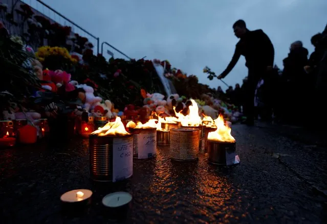 A man lays flowers at a makeshift memorial to the victims, set up outside the Crocus City Hall concert venue in the Moscow Region, Russia, on March 23, 2024. (Photo by Maxim Shemetov/Reuters)