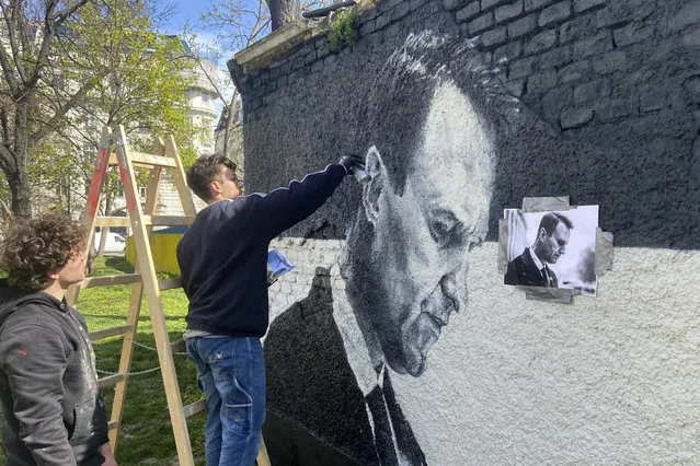 Austrian graffiti duo Joel Gamnou paint a picture of Alexei Navalny on a wall in Vienna, Austria, Wednesday, March 27, 2024. Two large portraits of the late Russian opposition leader Alexei Navalny have been spray-prainted on a property owned by the family of a former Czech foreign minister behind a monument to Soviet soldiers in Vienna. (Photo by Philipp-Moritz Jenne/AP Photo)