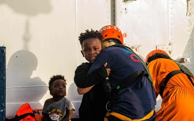 Handout picture taken on July 31, 2019 by German migrant rescue NGO Sea-Eye, shows children rescued off an overloaded rubber boat spotted in international waters off the Libyan coast, being brought on their vessel “Alan Kurdi”. The German aid organization Sea-Eye has rescued 40 people from an overcrowded rubber dinghy in the Mediterranean. The crew of the rescue ship “Alan Kurdi” discovered the migrants early morning on July 31, 2019 in international waters and took them on board, Sea-Eye said. The “Alan Kurdi” is now heading for the Italian Mediterranean island of Lampedusa. (Photo by Pavel Vitko/AFP Photo)