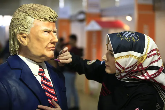 Turkish pastry chef Tuba Geckil adds the finishing touches to her figure of US President Donald Trump made out of cake icing which she created in two days, during a chocolate show in Istanbul, Saturday, March 25, 2017. (Photo by Lefteris Pitarakis/AP Photo)